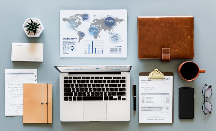 Pöydän päällä kannettava tietokone ja muita tarvikkeita