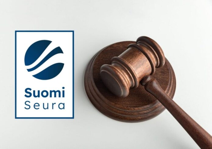 Kokousnuija pöydällä. Vieressä Suomi-Seuran logo.